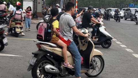 Nhiều phụ huynh Hà Nội không đội mũ bảo hiểm, lượn lách trong giờ tan tầm đi đón con