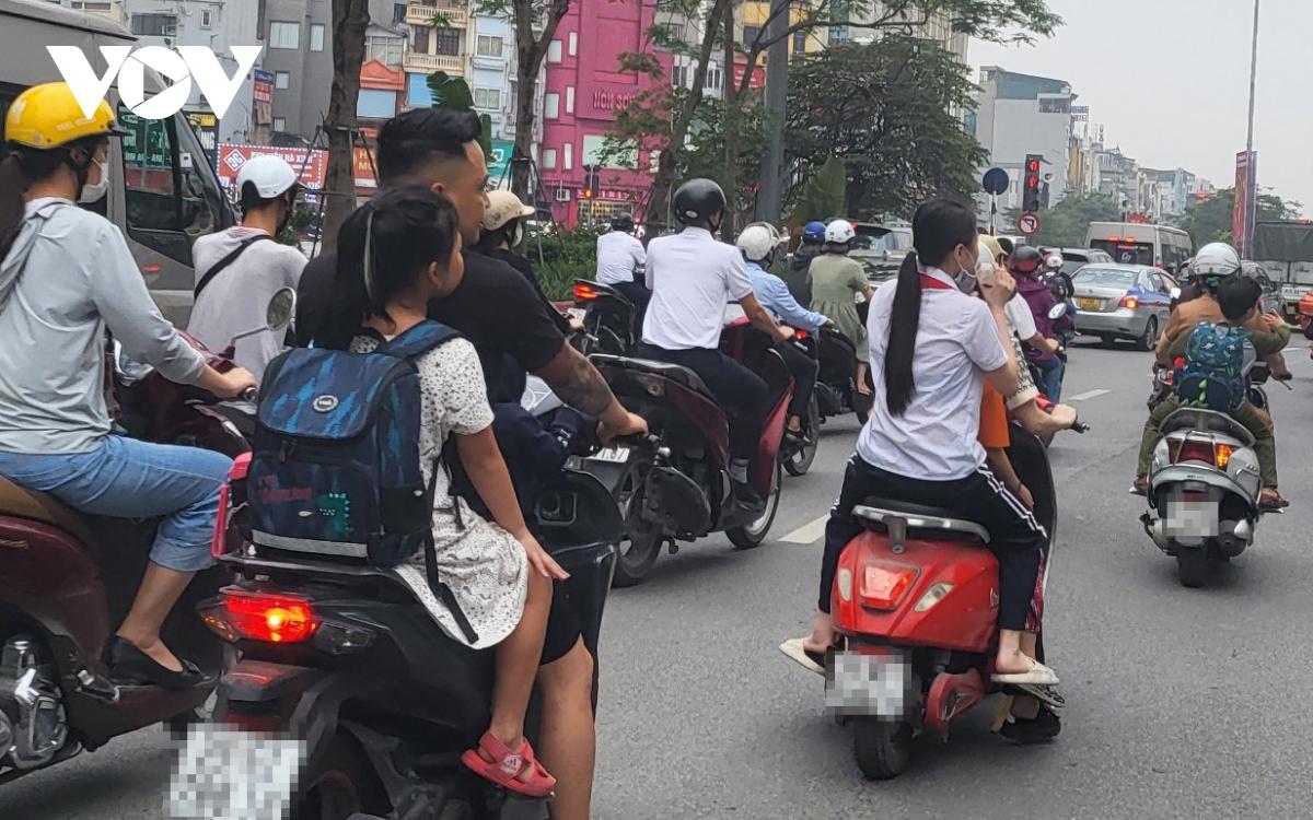 Nhiều phụ huynh Hà Nội không đội mũ bảo hiểm, lượn lách trong giờ tan tầm đi đón con - Ảnh 4.