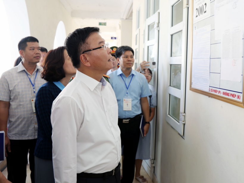 Phó Thủ tướng xem danh sách thí sinh, quy chế thi được niêm yết bên ngoài phòng thi. Ảnh: VGP/Đức Tuân