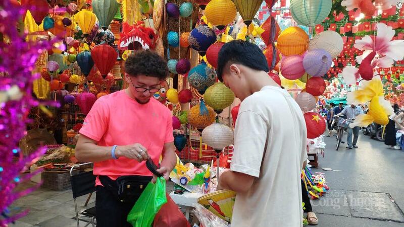 Một vị khách người nước ngoài mua nón truyền thống của Việt Nam với giá 30.000 đồng/chiếc.