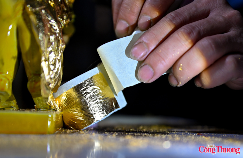 Từng lá vàng mỏng được nghệ nhân cẩn trọng đặt lên bề mặt tượng trong điều kiện độ ẩm, nhiệt độ được kiểm soát chặt chẽ.