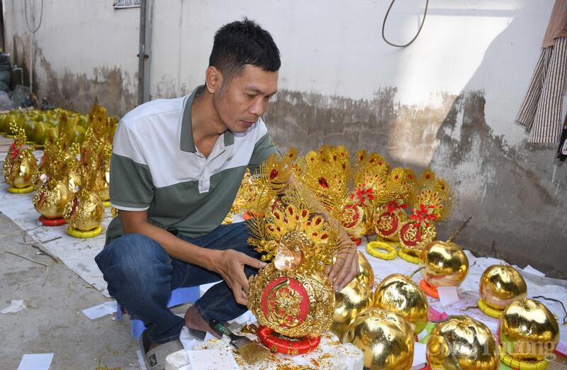 Anh Dình đang gấp rút hoàn thiện những công đoạn cuối cùng của sản phẩm trái dừa dát vàng để giao cho khách hàng.