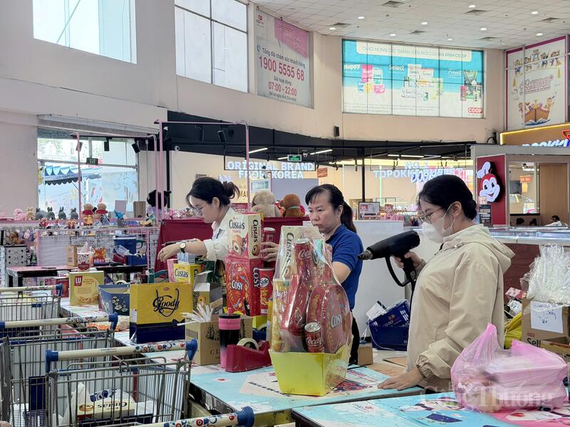 Tại các quầy gói quà theo yêu cầu, những sản phẩm thiết thực như bánh Cosy, nước giải khát... được ưu tiên lựa chọn để kết thành giỏ quà trang trọng. Ảnh: Minh Anh.