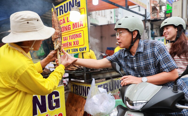 Người dân mua cá lóc nướng trên đường Tân Kỳ Tân Quý. Ảnh: Quỳnh Trần