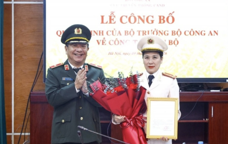 Thiếu tướng Đỗ Triệu Phong trao Quyết định và tặng hoa chúc mừng Đại tá Nguyễn Thị Thu Hằng. Ảnh: CAND