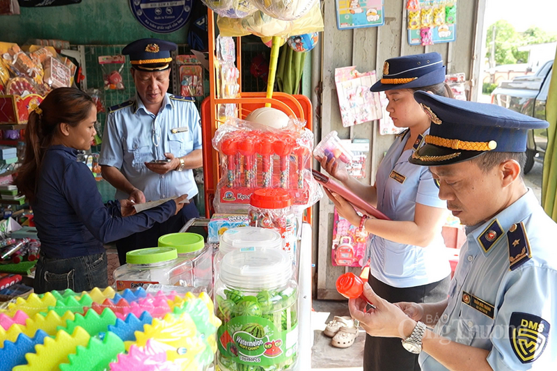 Lực lượng QLTT Hà Tĩnh kiểm tra tại một cửa hàng kinh doanh bánh kẹo trước cổng trường học. Ảnh: Thành Đô