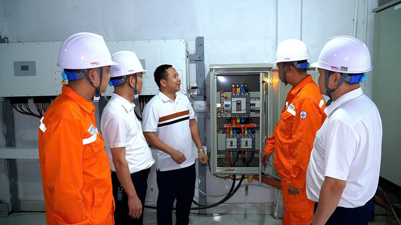Ông Nguyễn Huy Ngọc, Giám đốc Công ty TNHH Xuất khẩu may Phú Sơn, (người đứng giữa) phối hợp cùng cán bộ kỹ thuật Điện lực Lục Yên kiểm tra thông số vận hành của hệ thống inverter.