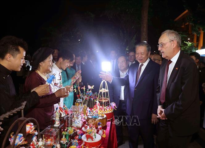 Tổng Bí thư, Chủ tịch nước Tô Lâm giới thiệu với Tổng thống Thụy Sĩ Guy Parmelin về nghệ thuật tò he - nét văn hóa dân gian độc đáo trên phố đi bộ. Ảnh: Thống Nhất - TTXVN